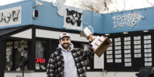 Owner of Holy Cow Cafe in Peabody Mike Schifino holds up a trophy from North American Ice Cream Association to celebrate winning 2022 flavor of the year.